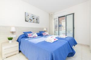 ein Schlafzimmer mit einem blauen Bett und Handtüchern darauf in der Unterkunft Apart-rent Apartamento Francesc Macia 1º 2001 in Roses