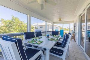 a dining room with a table and chairs on a balcony at Endless Summer, North Captiva Island in North Captiva