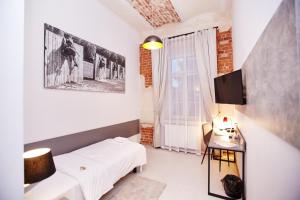 Un pat sau paturi într-o cameră la Koszary Arche Hotel