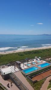 - une vue sur la plage avec 2 piscines dans l'établissement Apto pé na areia, à Barra Velha