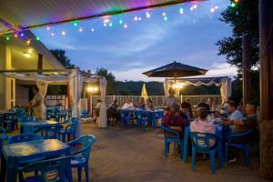 un grupo de personas sentadas en mesas en un restaurante en Camping du Lac de Saint-Pardoux, en Saint-Pardoux