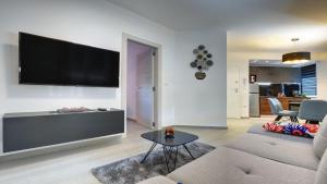 a living room with a couch and a tv on a wall at Exclusive Pula City Apartments in Pula