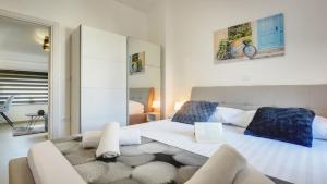 a bedroom with a large white bed and a couch at Exclusive Pula City Apartments in Pula