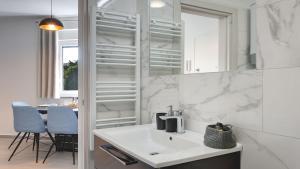 a white bathroom with a sink and blue chairs at Exclusive Pula City Apartments in Pula +39 photos