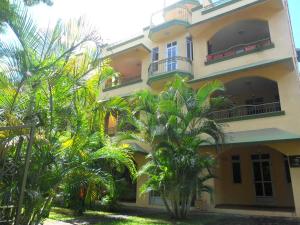un edificio giallo con palme di fronte di Sunway Residence a Mont Choisy