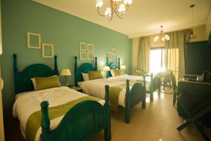 a bedroom with two beds and a chandelier at Holy Family Hotel in Jabal aţ Ţayr +37 photos