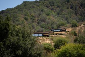 uma casa no topo de uma colina com árvores em Palcos de Apalta em Santa Cruz