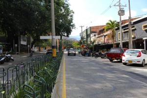 une rue avec des voitures garées sur le côté de la route dans l'établissement Hotel Laureles Park, à Medellín