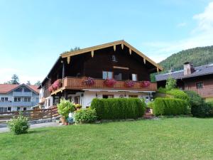 a house with a balcony with flowers on it at Gästehaus Berger inkl. Chiemgaukarte in Ruhpolding