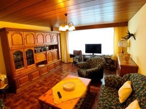a living room with a couch and chairs and a television at Gästehaus Berger inkl. Chiemgaukarte in Ruhpolding