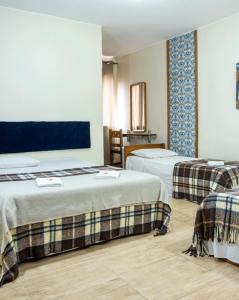 a hotel room with two beds in a room at Hotel Pousada Icaraí in Poços de Caldas +130 photos