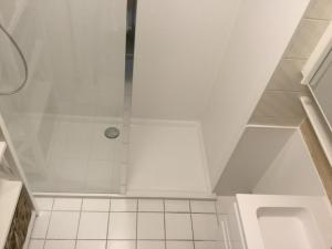 a bathroom with a shower and a tile floor at Panoramisch appartement tussen zee ,bos en de duinen in De Panne +6 photos