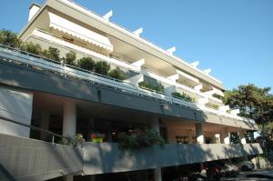 un edificio con un balcón con plantas. en Residence Isvico, en Lignano Sabbiadoro