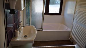 a bathroom with a sink and a bath tub at Ferien- und Businesswohnung Sonnentor Dreiländereck im zweiten Stock in Sonnen +40 photos