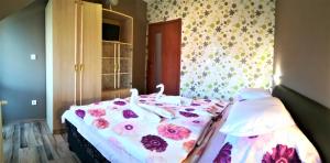 ハイドゥソボスローにあるFortuna Apartmanのベッドルーム1室(花の飾られたベッド1台付)