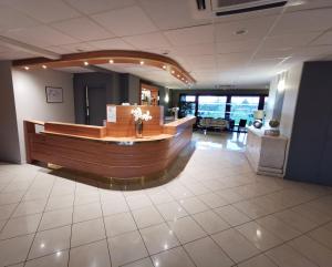 a large lobby with a reception desk in a building at Hotel Ambotel in Ambérieu-en-Bugey