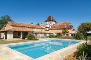 una casa con piscina di fronte a un edificio di Le Clos de Bourginel a Veyrines-de-Vergt