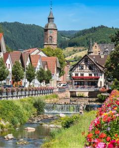 a small town with a river and a church at Hotel Restaurant Rebstock in Oppenau