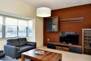 un soggiorno con poltrona e TV di 2 Bedroom Apartment - Spacious, Bright & Central - 4 a Msida