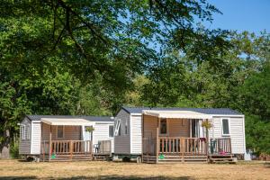 a mobile home with a porch and a deck at Camping de l'île in Bannay