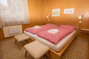 a small bedroom with a bed with a red and white blanket at Chalet Happy in Adelboden