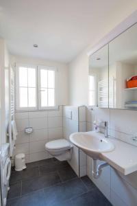 a white bathroom with a sink and a toilet at Chalet Happy in Adelboden