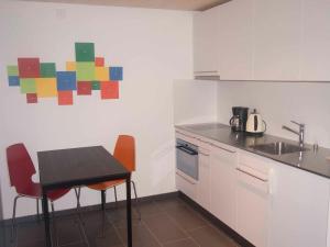 a kitchen with a table and chairs and a sink at Studio Zentrum EG in Adelboden