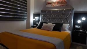 ein Schlafzimmer mit einem großen Bett mit einem Kopfteil aus Metall in der Unterkunft Apartaments y Habitacions Entre Volcans in Olot