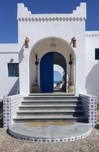 ein Gebäude mit einer blauen Tür und einer Treppe in der Unterkunft Dar Chick Yahia Ile De Djerba in Mezrane