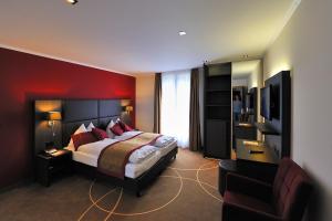 a bedroom with a bed with a red wall at Hotel Central in Engelberg