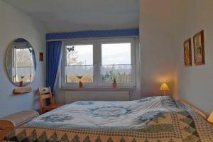 um quarto com uma cama e duas janelas em SI30v FeWo Stoer em Dorum Neufeld