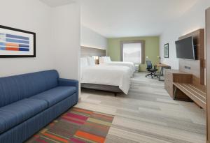 a hotel room with a bed and a couch at Holiday Inn Express & Suites - Plano - The Colony, an IHG Hotel in The Colony