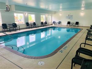 a large swimming pool with chairs and tables at Comfort Inn & Suites Conway in Conway