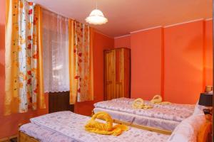2 letti in una camera con pareti arancioni di Фън Шуй Къща за гости 88 a Dobrinishte
