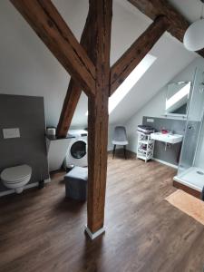 a large attic room with a wooden beam at FeWo Rohleder de mit 130m2 und Garten für 6Pers mit 2 Bad in Cottbus +22 photos