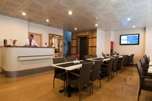 a man standing at a counter in a restaurant with tables and chairs at Haydarpasa Hotel in Istanbul