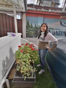 a woman standing next to a potted plant at Hotel Andino in Quito