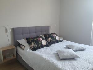 una cama con dos almohadas encima en Apartament Słoneczny 28 Słoneczna Dolina, en Jastrzębia Góra