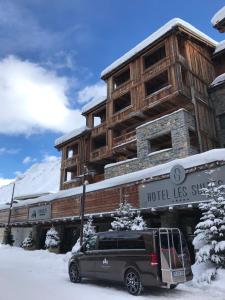 
a truck parked on the side of a snow covered building at Les Suites – Maison Bouvier in Tignes

