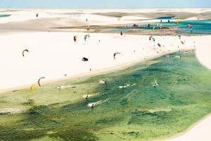 eine Gruppe von Menschen an einem Strand, die Drachen fliegen in der Unterkunft Casa do PESCADOR Atins - c/ todo conforto e super localização in Atins