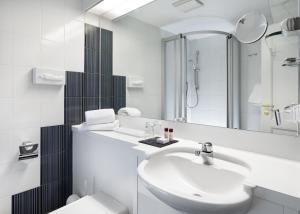 een witte badkamer met een wastafel en een spiegel bij Boutique Hotel 3 Stuben in Meersburg