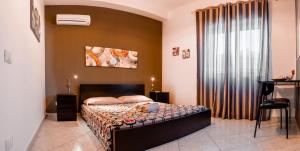 a bedroom with a bed and a large window at Villa Concordia in Villaggio Mosè