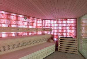 a room with pink walls and wooden benches at The Phoenicia Malta in Valletta