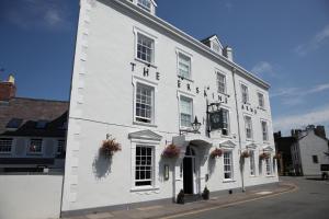a white building with flowers on the front of it at The Erskine Arms in Conwy