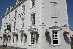 ein weißes Gebäude mit Blumenkästen an den Fenstern in der Unterkunft The Erskine Arms in Conwy