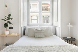 a bedroom with a white bed with a window at Update Urban Chic Flat in 19th Century Building 2 Bedrooms & 2 Bathrooms & AC Central Alfama District in Lisbon