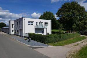 a white house on the side of a street at Landferien Eifel in Pittenbach