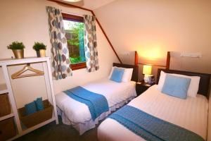 Habitación pequeña con 2 camas y ventana en Ericht Holiday Lodges en Blairgowrie