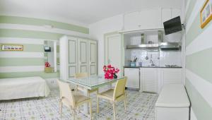 Hotel Residence Mendolita في ليباري: مطبخ وغرفة طعام مع طاولة وكراسي
