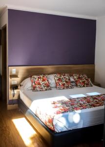 Un dormitorio con una cama grande con almohadas. en Hotel Poma Rosa en Medellín